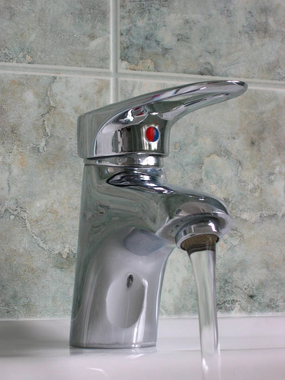 Chrome mixer tap running over a basin
